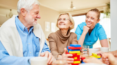 caregiver taking care of seniors playing with blocks