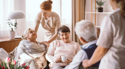 caregivers comforting elderly women and man in nursing home